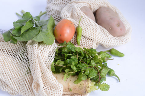Mesh cotton bags with vegetables top view